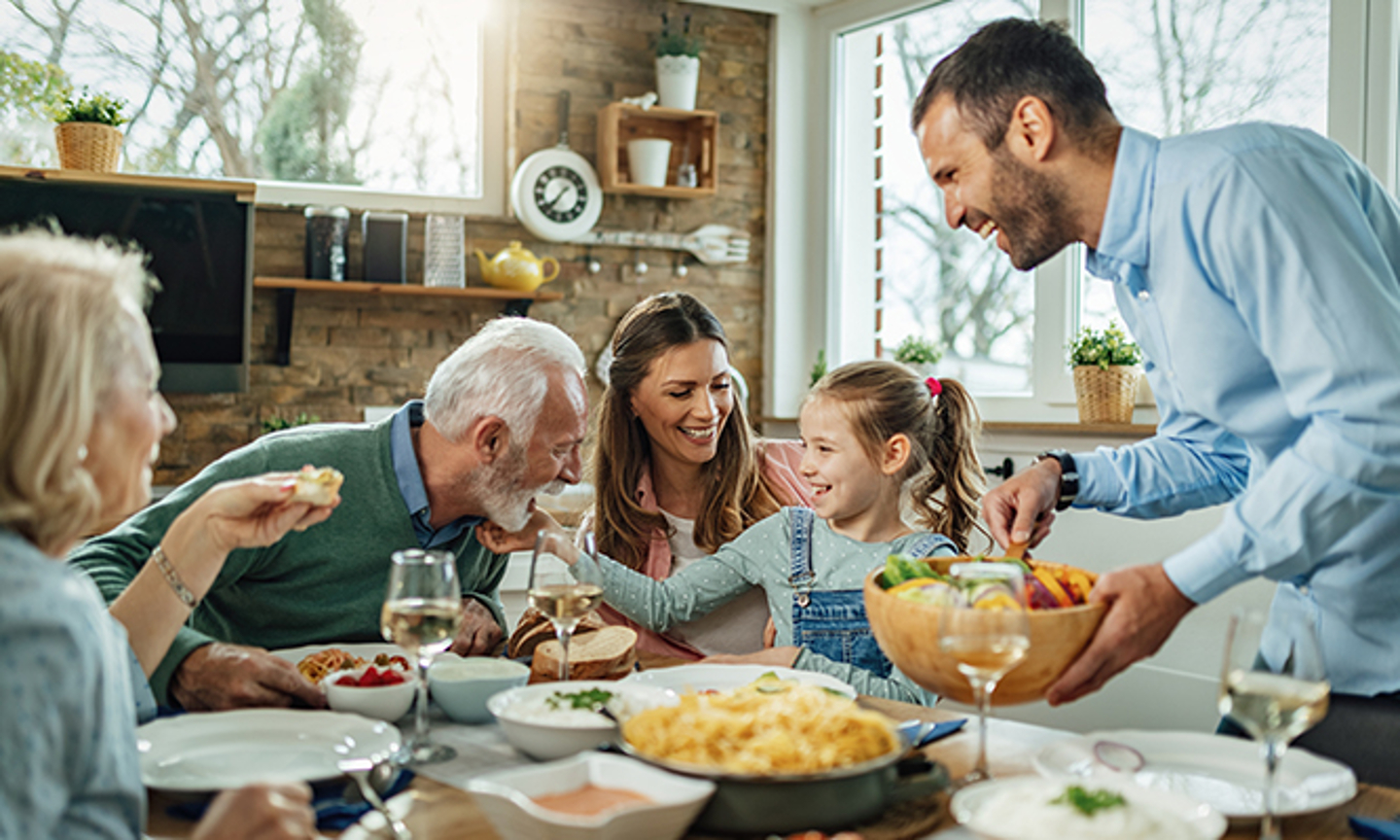 Familia feliz comiendo en el comedor de su casa